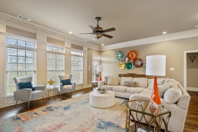 living room featuring ornamental molding, dark wood-style flooring, visible vents, and baseboards