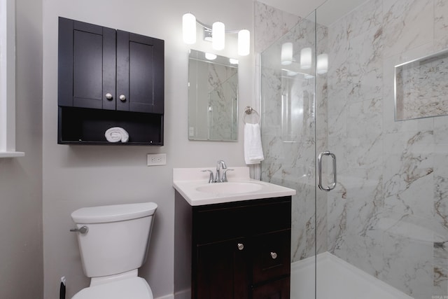 bathroom featuring toilet, vanity, and a marble finish shower