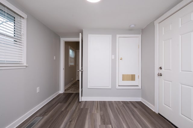 interior space with visible vents, baseboards, and dark wood-type flooring