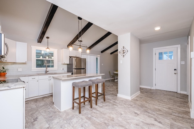 kitchen featuring stainless steel appliances, white cabinetry, and a kitchen island