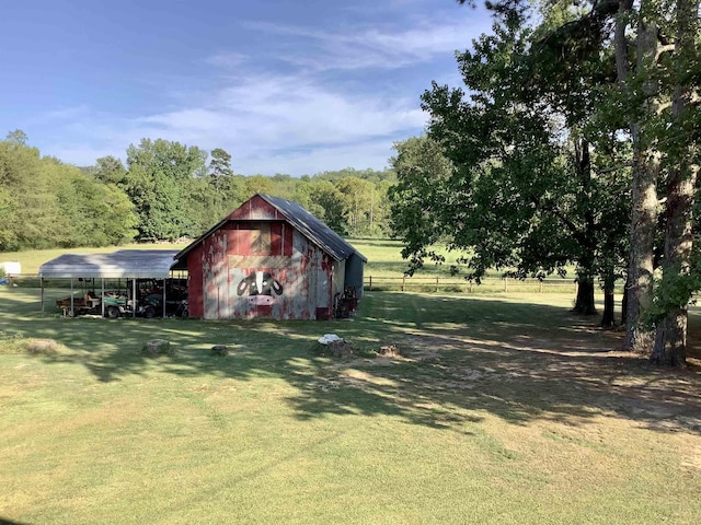 view of yard featuring a carport, a barn, and an outbuilding