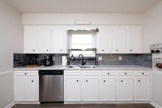 kitchen featuring light countertops, dishwasher, a sink, and white cabinetry