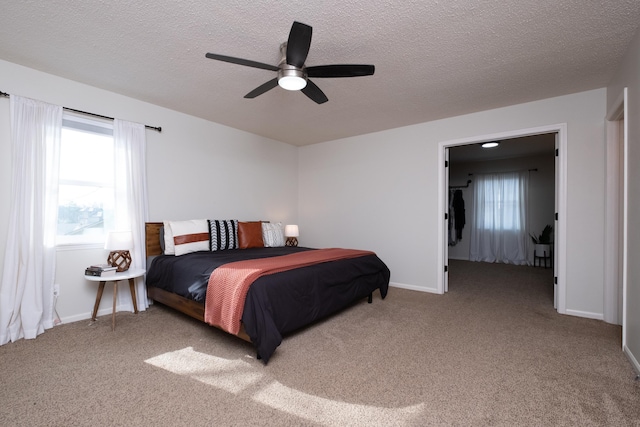 bedroom featuring carpet, baseboards, and a textured ceiling