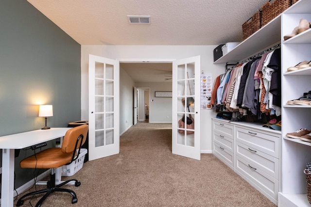 spacious closet featuring visible vents, light colored carpet, and french doors