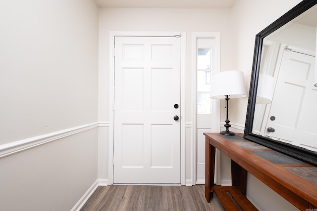 foyer entrance featuring baseboards and wood finished floors