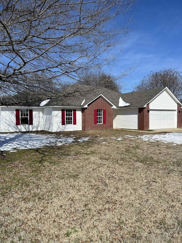 ranch-style home featuring a garage, brick siding, and a front yard