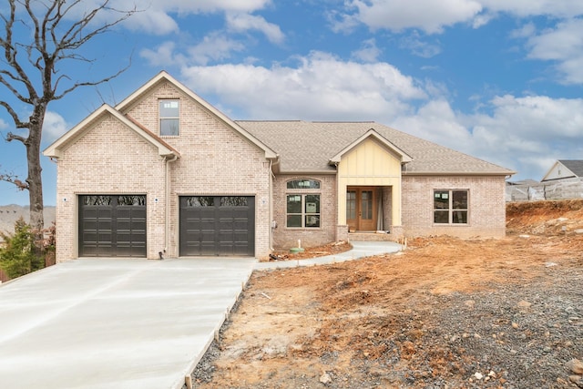 view of front of house with concrete driveway, brick siding, and a shingled roof