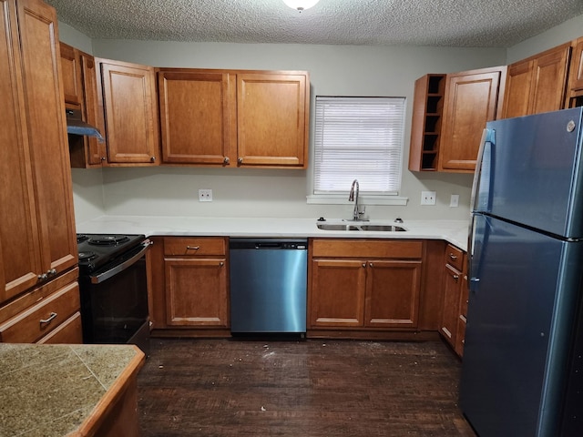 kitchen featuring brown cabinets, a sink, under cabinet range hood, and black appliances