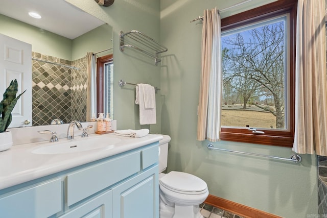 full bath with toilet, vanity, a wealth of natural light, and baseboards
