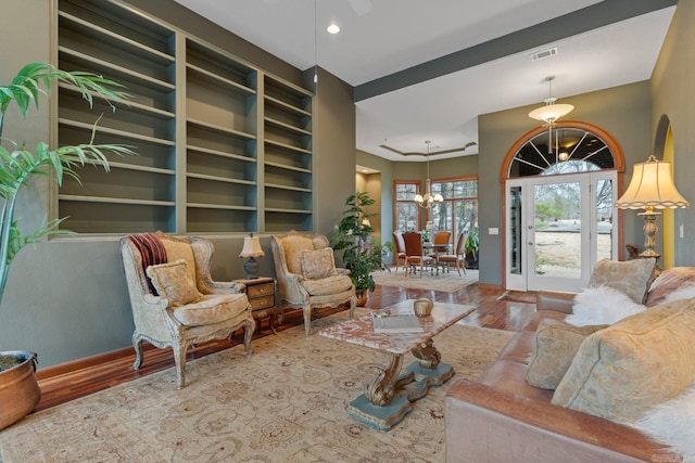living area featuring recessed lighting, wood finished floors, visible vents, baseboards, and an inviting chandelier