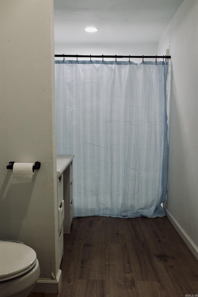 full bathroom featuring vanity, wood finished floors, toilet, and baseboards