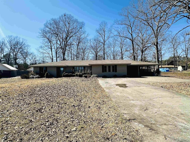 ranch-style home featuring concrete driveway, an attached carport, and a water view