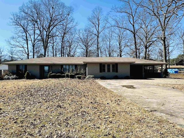 ranch-style house featuring driveway, a carport, and brick siding