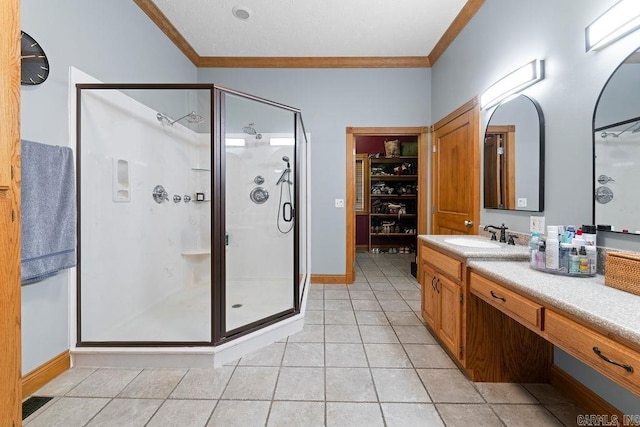 full bathroom with a stall shower, tile patterned flooring, crown molding, and vanity