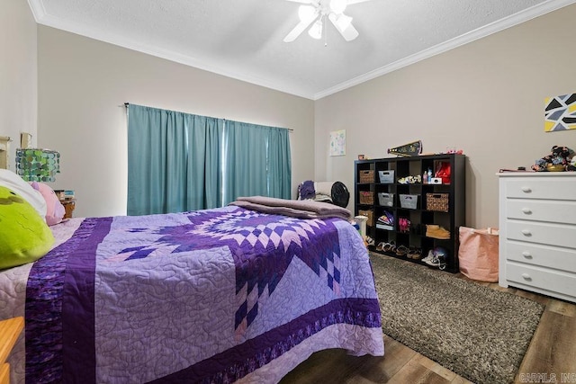 bedroom with crown molding, ceiling fan, and wood finished floors