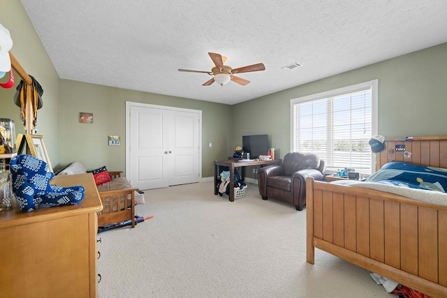 bedroom with ceiling fan, visible vents, a textured ceiling, and light colored carpet
