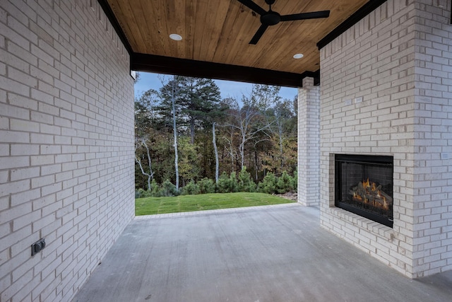 view of patio with an outdoor brick fireplace and ceiling fan