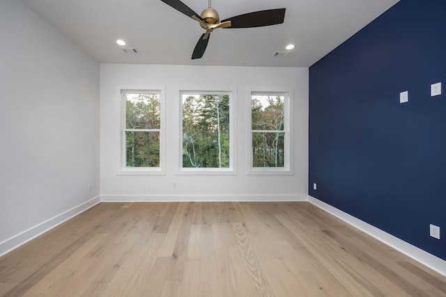 empty room with plenty of natural light, light wood-style flooring, and baseboards
