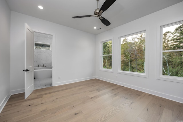 unfurnished bedroom featuring baseboards, recessed lighting, connected bathroom, and light wood-style floors