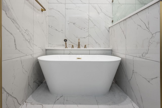 bathroom with a soaking tub and stone wall