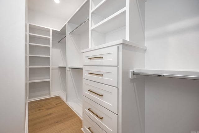 walk in closet with light wood-style flooring