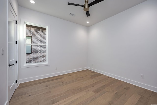 spare room with baseboards, a ceiling fan, visible vents, and light wood-style floors