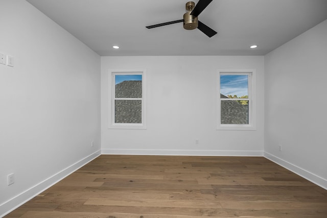 empty room with recessed lighting, wood finished floors, and baseboards