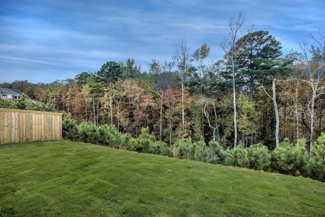 view of yard with fence and a forest view