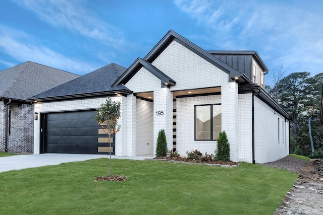 view of front of house featuring a front lawn, brick siding, driveway, and an attached garage