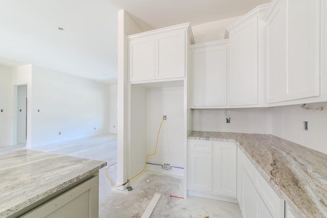 kitchen with white cabinetry and light stone countertops