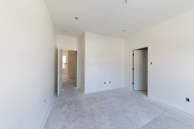 unfurnished bedroom featuring unfinished concrete flooring and baseboards