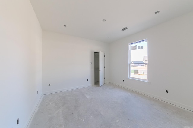 unfurnished room featuring visible vents, unfinished concrete floors, and baseboards