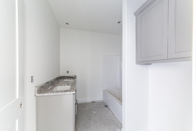 full bathroom with bathing tub / shower combination, unfinished concrete floors, and vanity