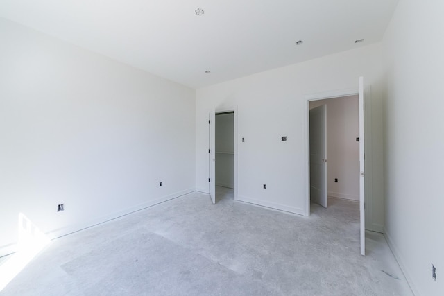 unfurnished bedroom featuring concrete floors and baseboards