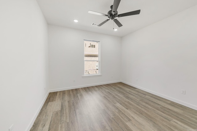 spare room featuring a ceiling fan, visible vents, recessed lighting, wood finished floors, and baseboards