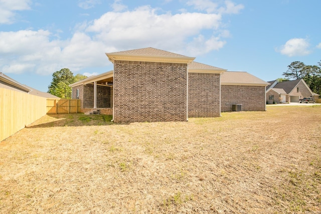 back of house with brick siding and fence