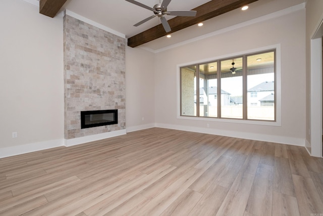 unfurnished living room with baseboards, beamed ceiling, light wood-type flooring, a fireplace, and recessed lighting