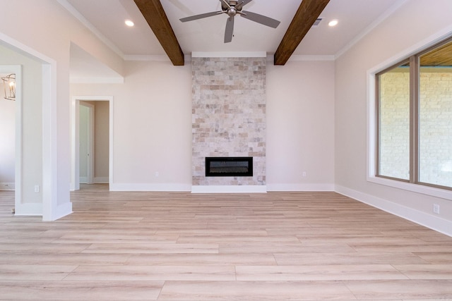 unfurnished living room featuring light wood-type flooring, beamed ceiling, a fireplace, and baseboards