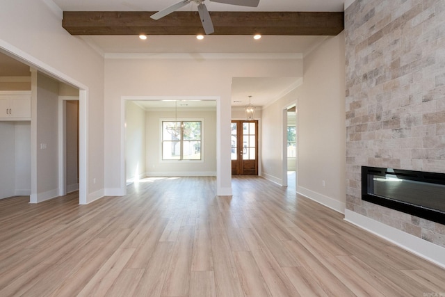 unfurnished living room featuring light wood finished floors, a fireplace, and beam ceiling