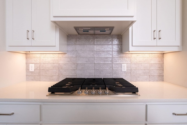 kitchen with white cabinets, premium range hood, stainless steel gas stovetop, and light countertops