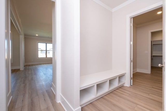 mudroom featuring light wood-type flooring, crown molding, and baseboards