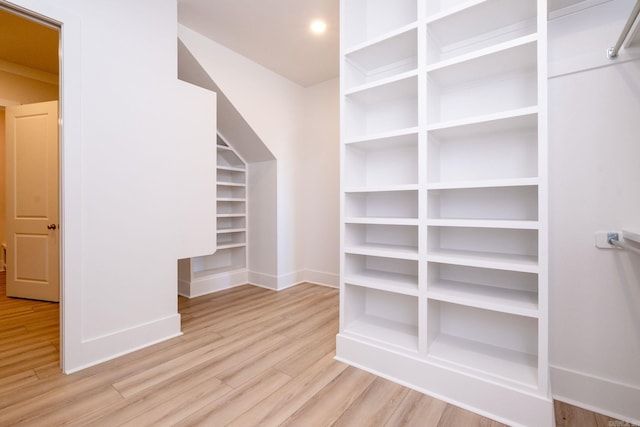 walk in closet with light wood-style flooring