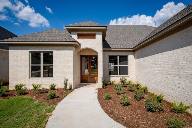 property entrance with roof with shingles and french doors