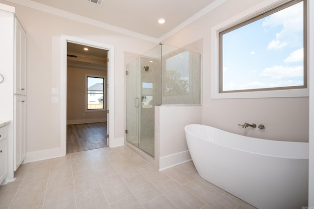 full bathroom with vanity, baseboards, ornamental molding, a soaking tub, and a shower stall