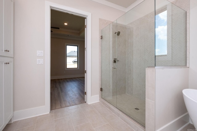 full bath with ornamental molding, a shower stall, baseboards, and tile patterned floors