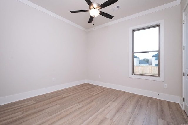 unfurnished room with baseboards, ornamental molding, visible vents, and light wood-style floors