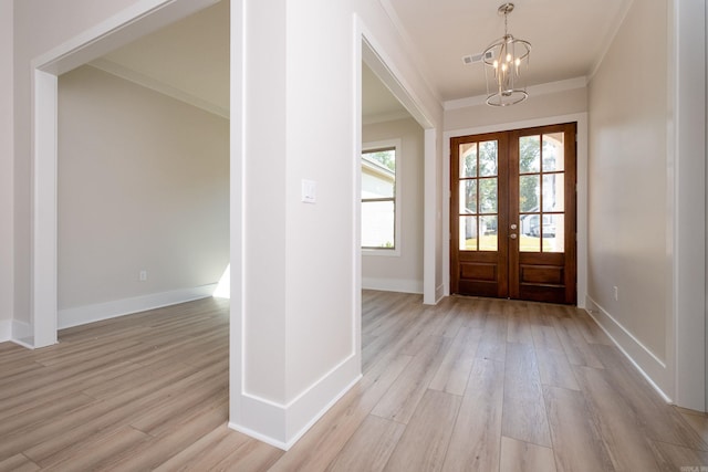 foyer with light wood-style flooring, ornamental molding, and a wealth of natural light