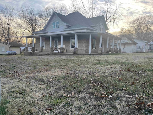 farmhouse with covered porch and a front lawn