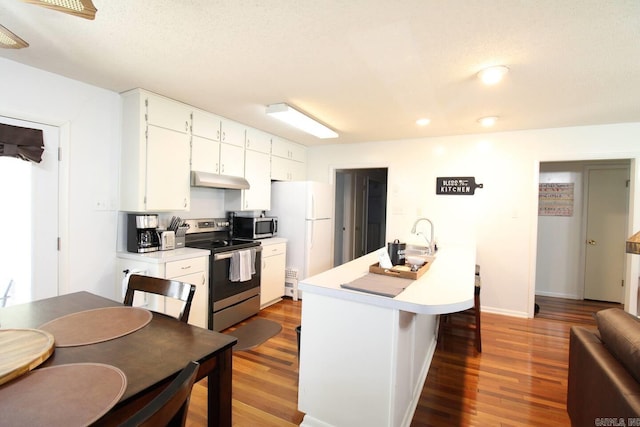 kitchen with white cabinetry, appliances with stainless steel finishes, light countertops, and wood finished floors