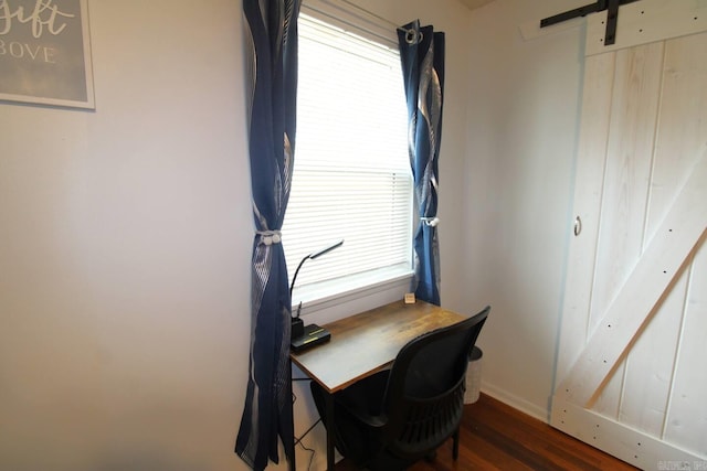 office featuring a barn door and dark wood finished floors